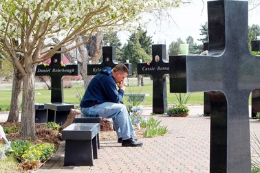 Dustin Gorton, 30 de ani, spune o rugăciune în timp ce vizitează un memorial miercuri, 20 aprilie 2011, în Littleton, Colorado, pentru cei care au fost uciși la împușcătura la liceul Columbine acum 12 ani. Foto: Profimedia