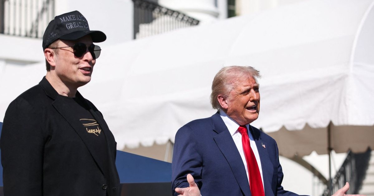 Elon Musk se uită la președintele Donald Trump care vorbește în fața mașinilor Tesla la Casa Albă din Washington, SUA