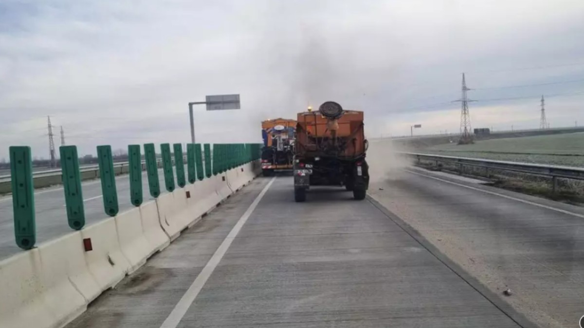 Două utilaje care fac lucrări pe un drum