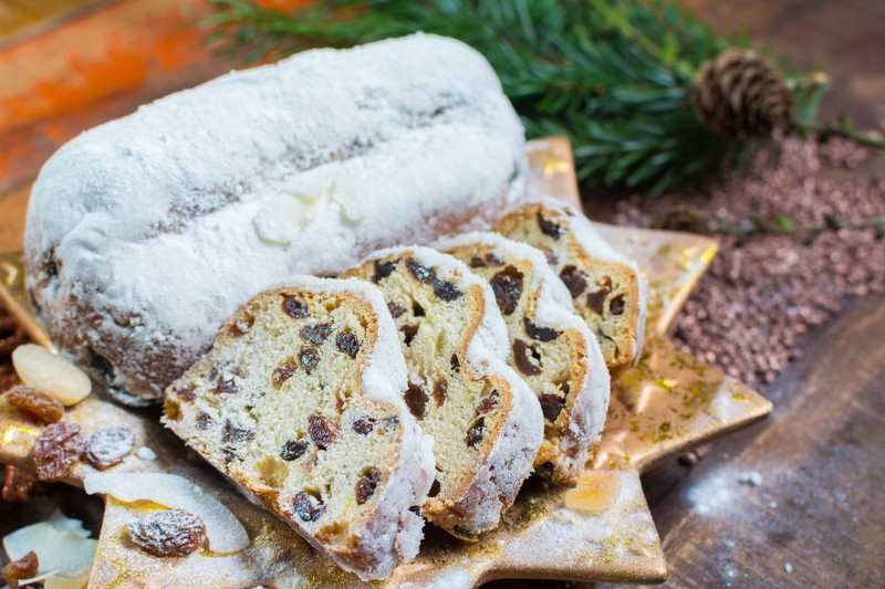 90684133 - traditional german christmas raisins and dried fruits cake with sugar powder and christmas decorations close up