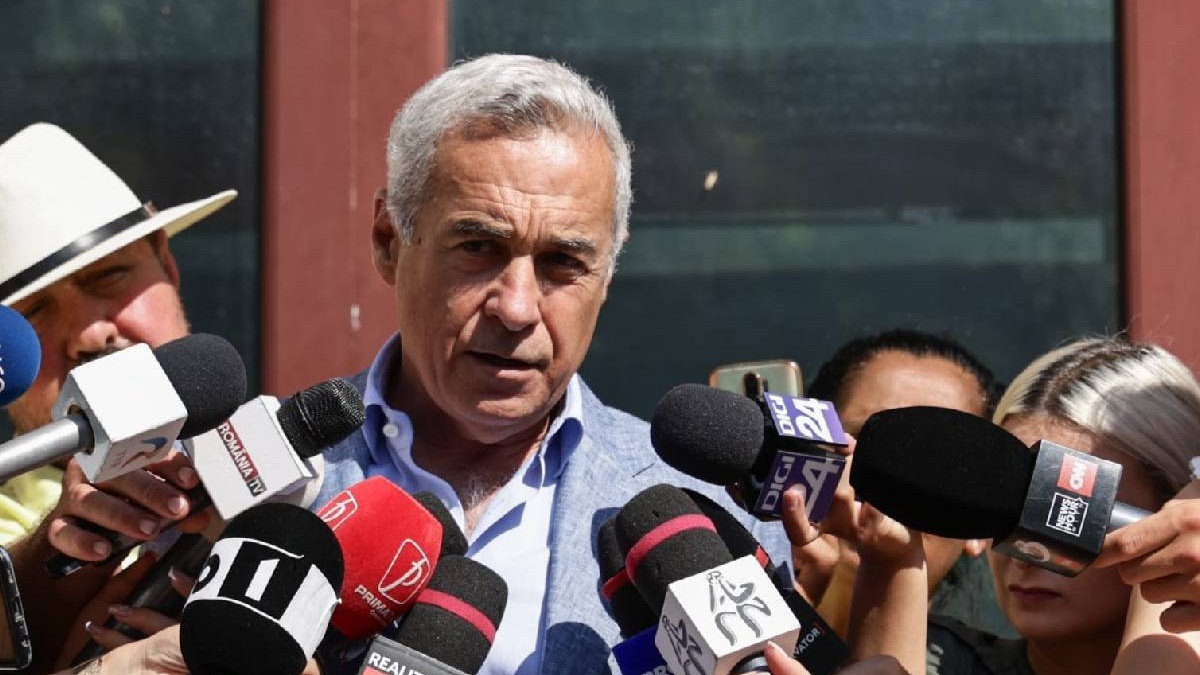 Călin Georgescu vorbește cu jurnaliștii la ieșirea din Parchet. e îmbrăcat cu un costum și are o figură gravă