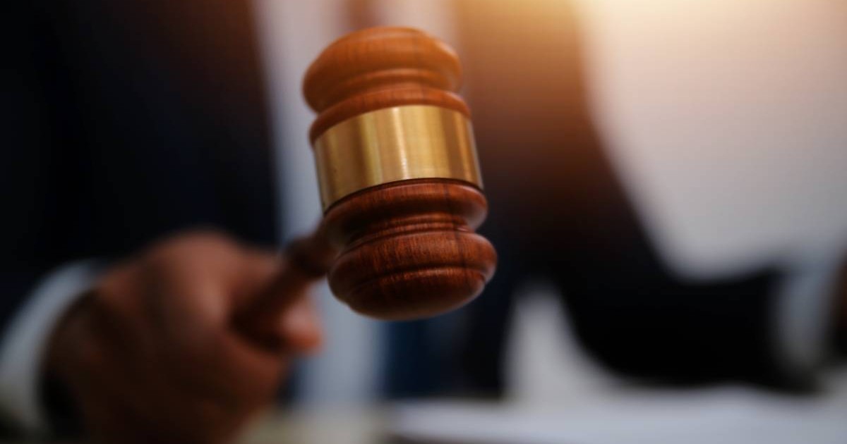 Ciocan judecătoresc, ținut în mână de un judecător îmbrăcat cu o robă specifică.