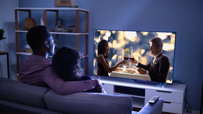 Cuplu care se uită la televizor acasă