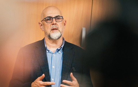 Kelemen Hunor, președintele UDMR, în timpul unui discurs. Acesta poartă o cămașă albastră și gesticulează cu ambele mâini