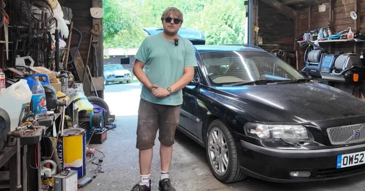 Un băiat blond care poartă tricou turcoaz, într-un service auto