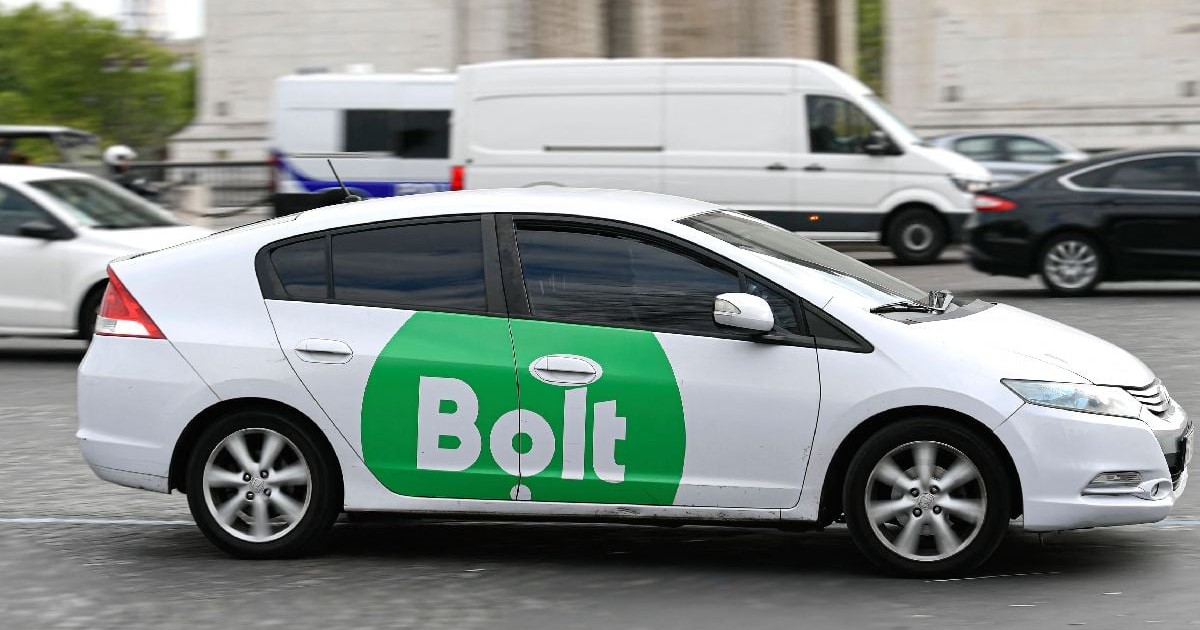 O mașină albă pe care e inscripționată cu verde sigla Bolt