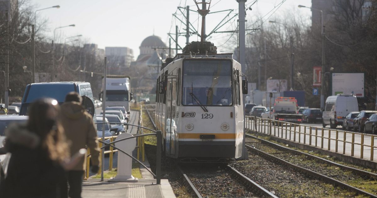 București, România, Tramvai vechi care sosește într-o stație de pe un bulevard din București într-o zi însorită de iarnă.
