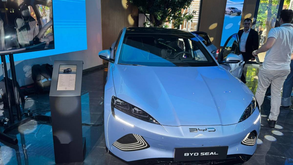 Modelul electric BYD Seal, expus în cadrul evenimentului oficial de lansare a brandului BYD în România. În jurul mașinii sunt participanți la eveniment care analizează