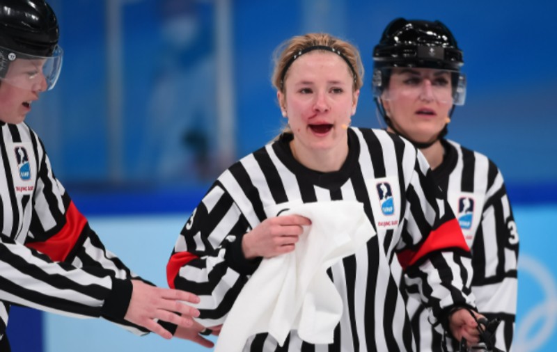 Arbitră plină de sânge, după ce a fost lovită accidental cu crosa, în timpul meciului de hochei Canada - SUA, din turneul olimpic feminin