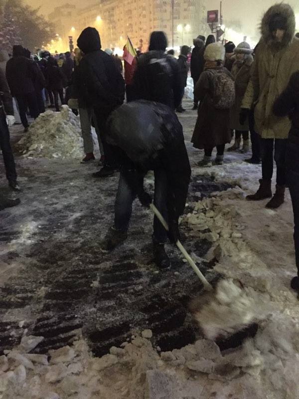 Acest bărbat curăță de zăpadă scuarul din fața Guvernului