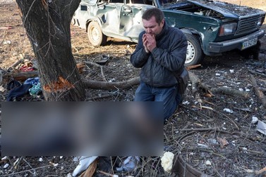 Un bărbat plânge moartea unei persoane, în fața unui un bloc lovit de bombardamentul rusesc în Ciuhuiiv, lângă orașul Harkov FOTO: Hepta