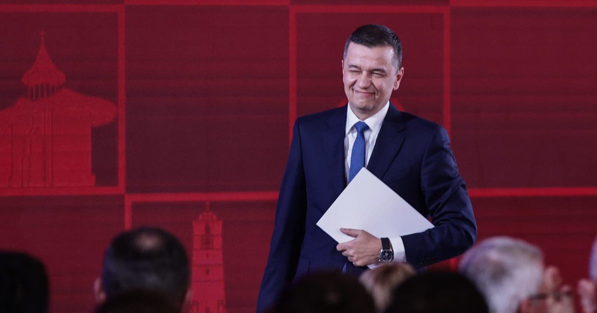 Sorin Grindeanu în costum negru, cămașă albă, în timp ce zâmbește