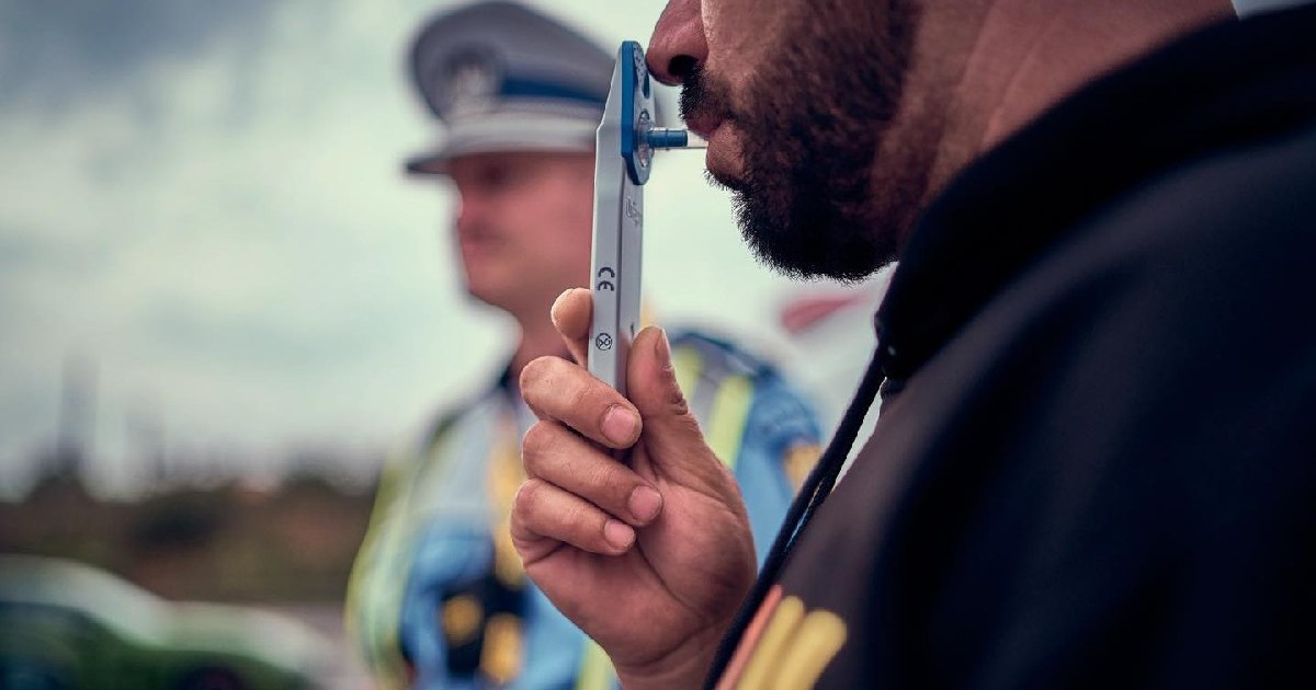 un politist și un șofer care suflă într-un drugtest