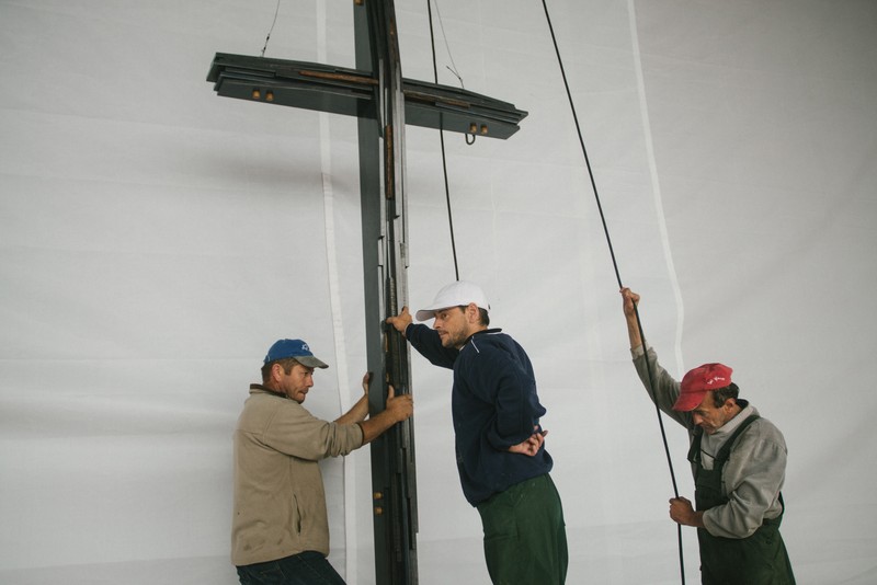Tehnicieni instalând o cruce pe scena pregătită pe Câmpia Libertății din Blaj cu ocazia vizitei Sanctității Sale Papa Francisc, Blaj, 1 iunie 2019 © Mircea Reștea / Documentaria.