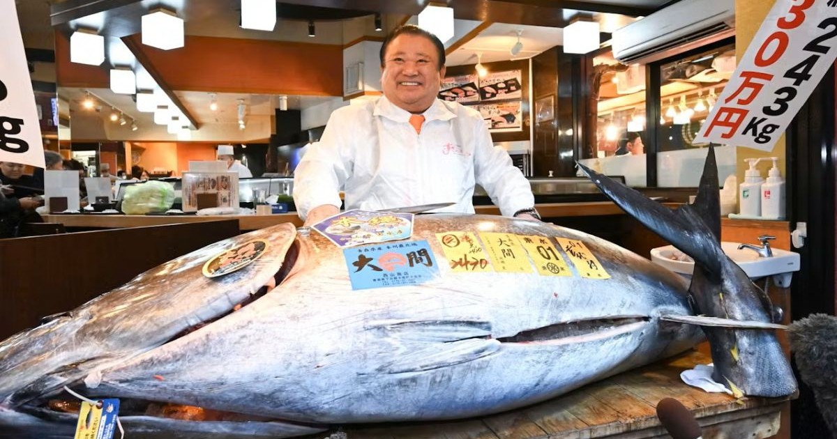Un bărbat, proprietarul unui lanț de restaurante de sushi, alături de un ton roșu uriaș, de 243 de kilograme, pentru care a plătit un preț-record de 2,8 milioane de euro, la licitația de Anul Nou organizată pe principala piață de pește din Tokyo, 5 ianuarie 2026