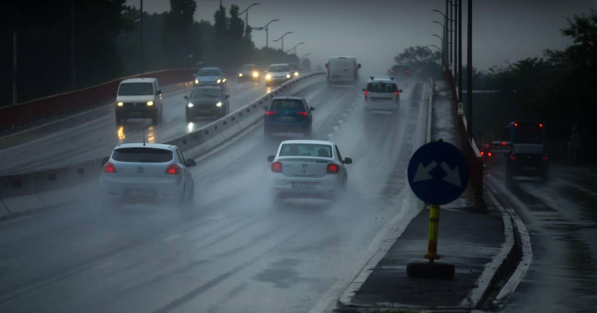 Mașinile din București mergând pe drumul aglomerat într-o zi ploioasă și întunecată de primăvară.