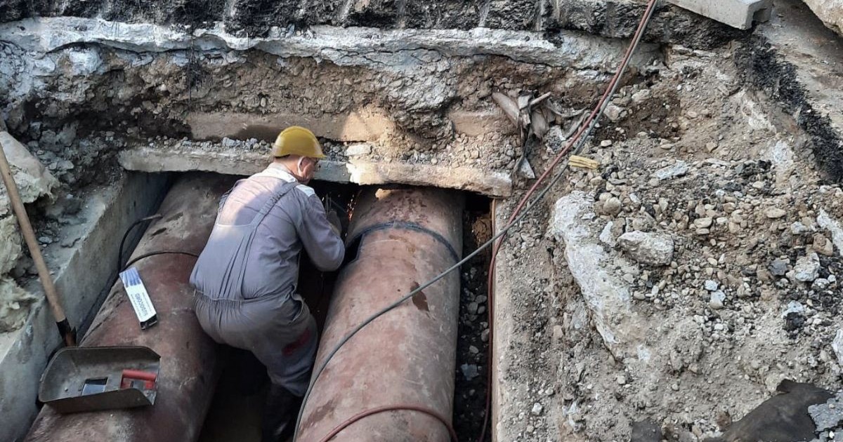 Muncitor al Termoenergetica București în timp ce lucrează la o țeavă, în șantier