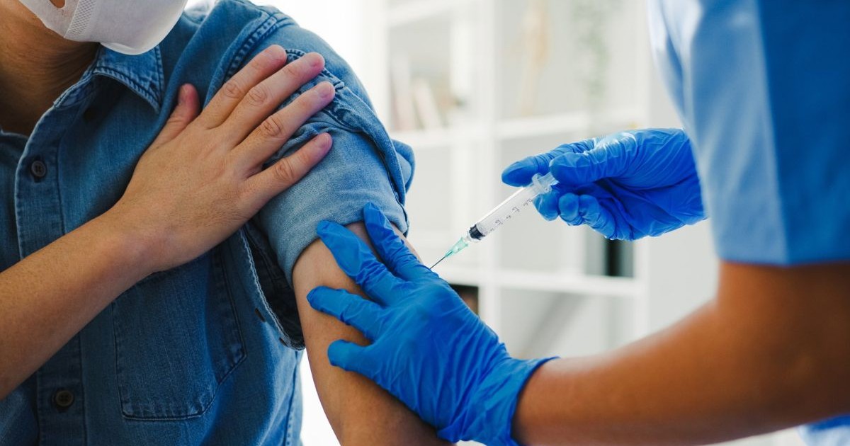 o asistentă medicală administrează un vaccin unui pacient