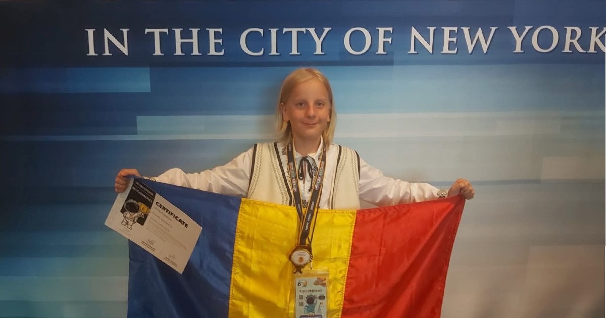 Eduard Ștefan, elev român, ține în mâini steagul României și poartă la gât medalia de aur, după ce a câștigat premiul I la Olimpiada Internațională de Matematică din SUA.