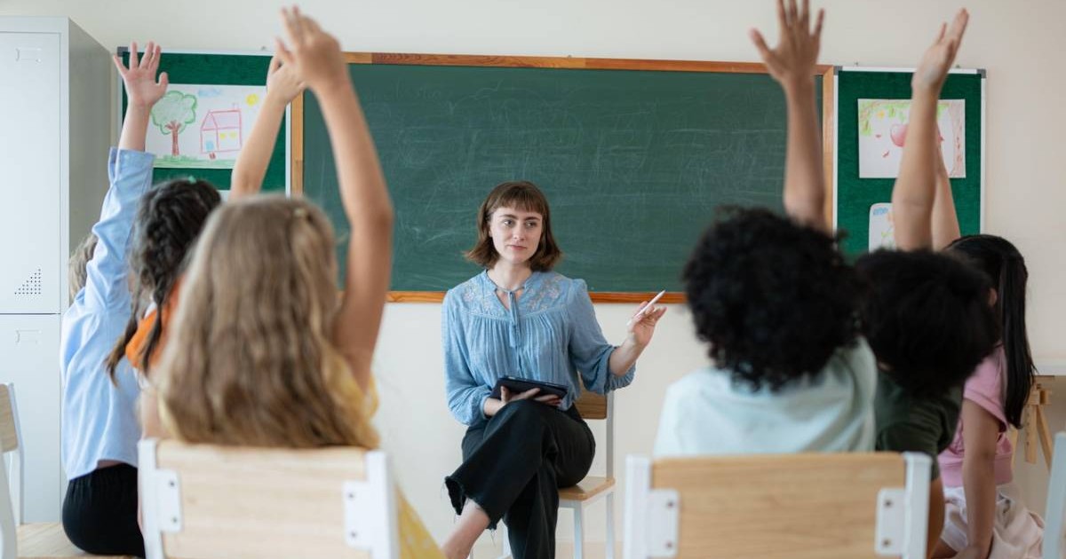 Profesori și elevi, învață și studiază într-o sală de clasă unde tinerii stau și ascultă cu atenție.