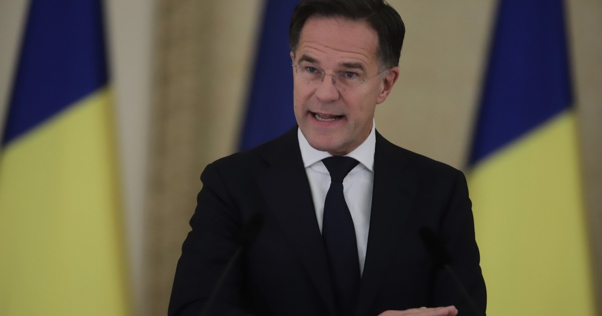 Mark Rutte, seful NATO, in picioare, la pupitru, in costum de culoare inchisa, cravata albastra si camasa alba