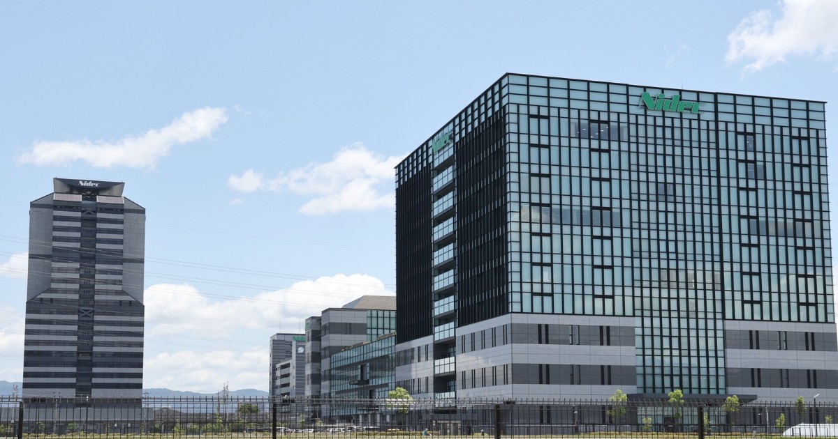 Clădirea sediului Nidec, un complex modern din sticlă, sub un cer senin.