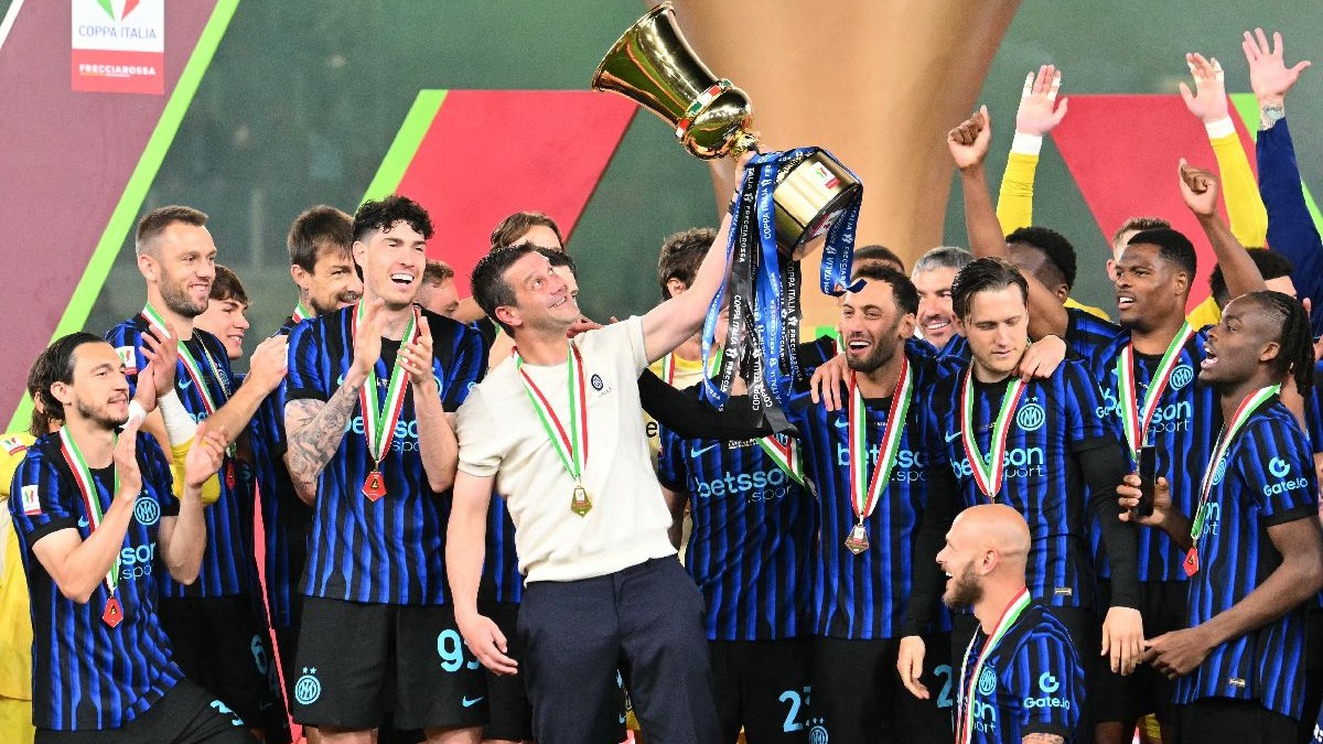 Mai mulți fotbaliști ai lui Inter, în tricouri albastru negru și în fața loc Cristi Chivu, în tricou alb, cu Cupa Italiei într-o mână
