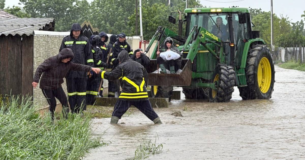 Pompierii militari în timp ce evacuează cu un tractor patru locuitori din Botoșani, în timpul inundațiilor