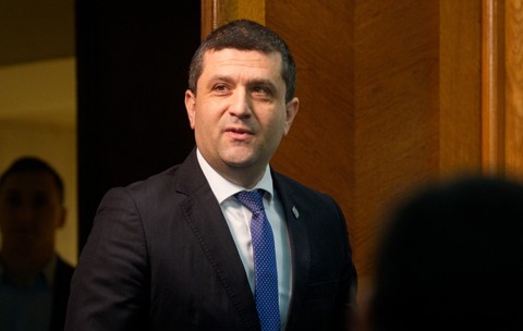 Radu Miruță în costum negru în timp ce zâmbește