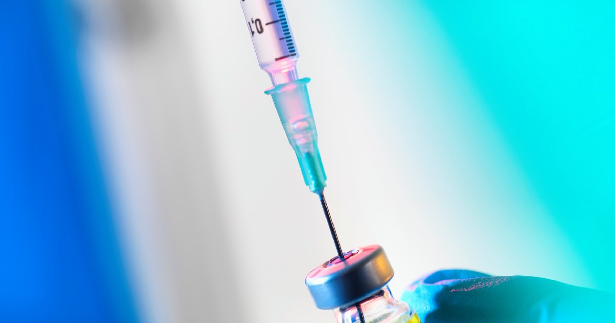 O seringă este introdusă într-un flacon cu vaccin