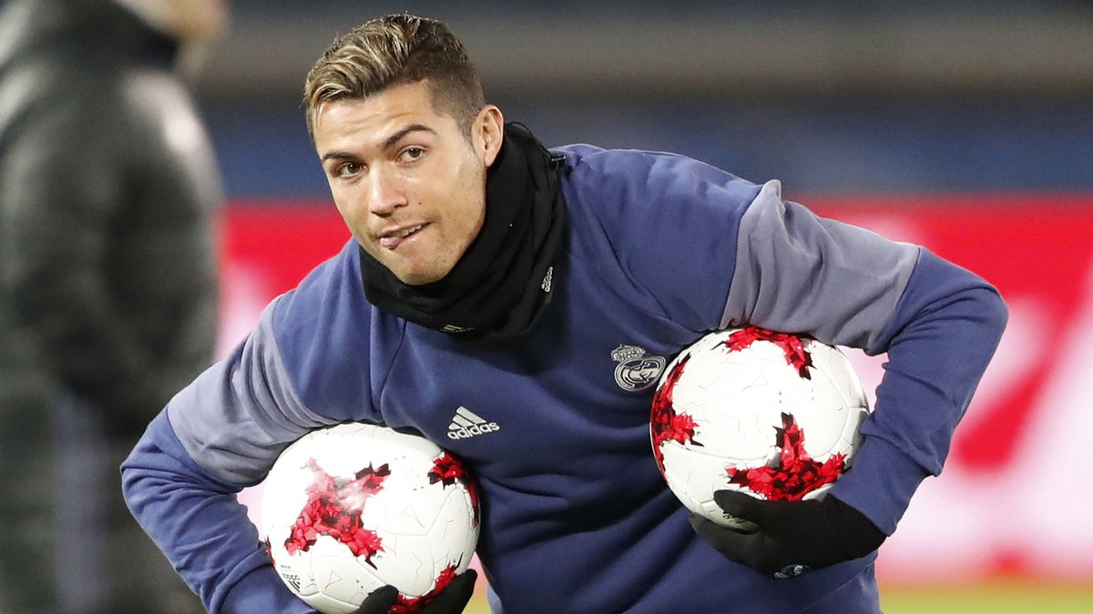 Cristiano Ronaldo, purtând în braţe două mingi de fotbal în timpul unui antrenament al lui Real Madrid. (FOTO: HEPTA)