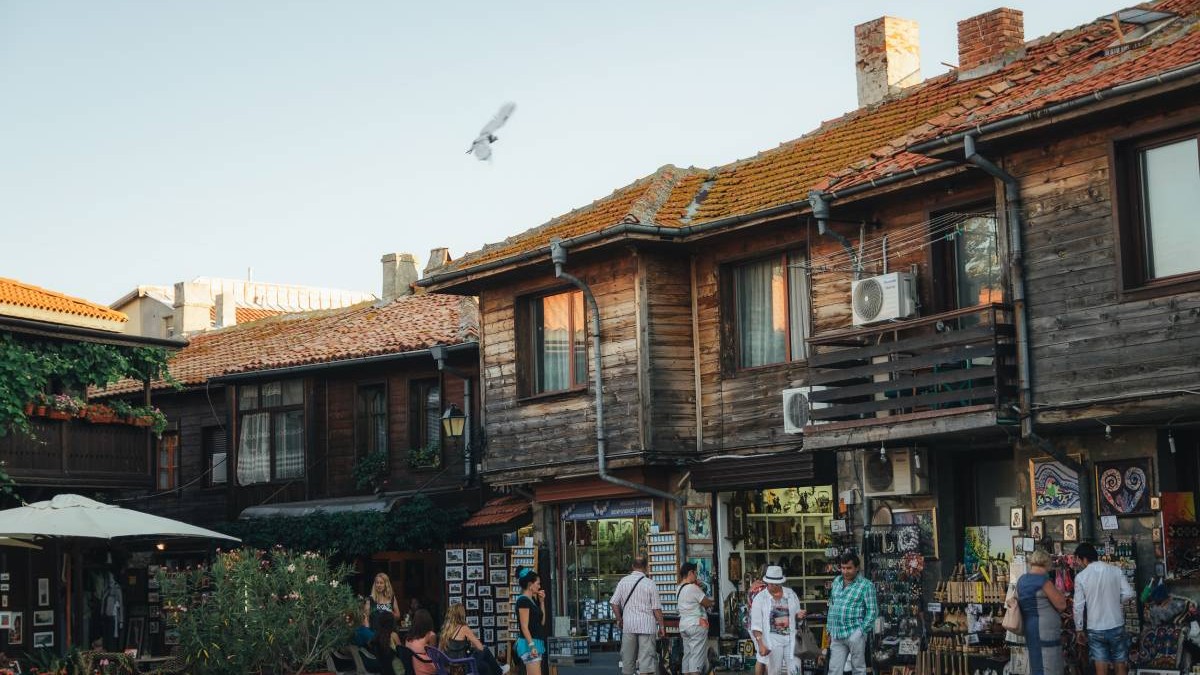 Mai multe magazine din bazarul din Nessebar Old Town, oamenii se uită la tarabe și cumpără magneți de frigider