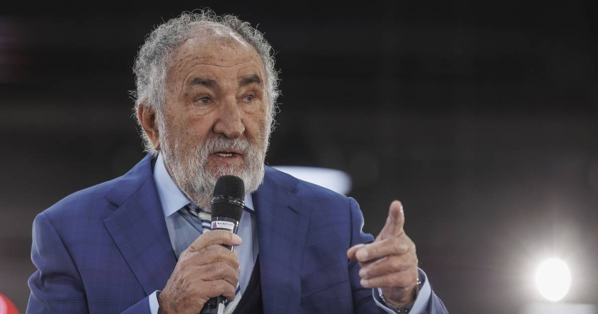 ion tiriac imbracat intr-un sacou albastru in timpul unei conferinte vorbind la un microfon