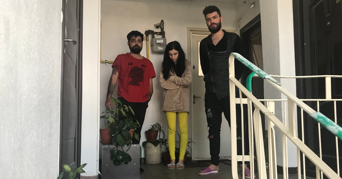 Sorin, Ioana, soția lui, și vărul Alexandru Gabriel (de la stânga), în fața ușii apartamentului lor din Ploiești.