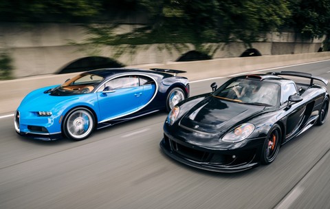 Un bugatti albastru și un porsche negru pe o șosea