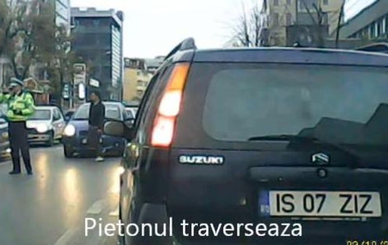 Un poliţist vorbeşte la telefon în intersecţie, în timp ce pietonii traversează NEREGULAMENTAR prin SPATELE LUI | VIDEO