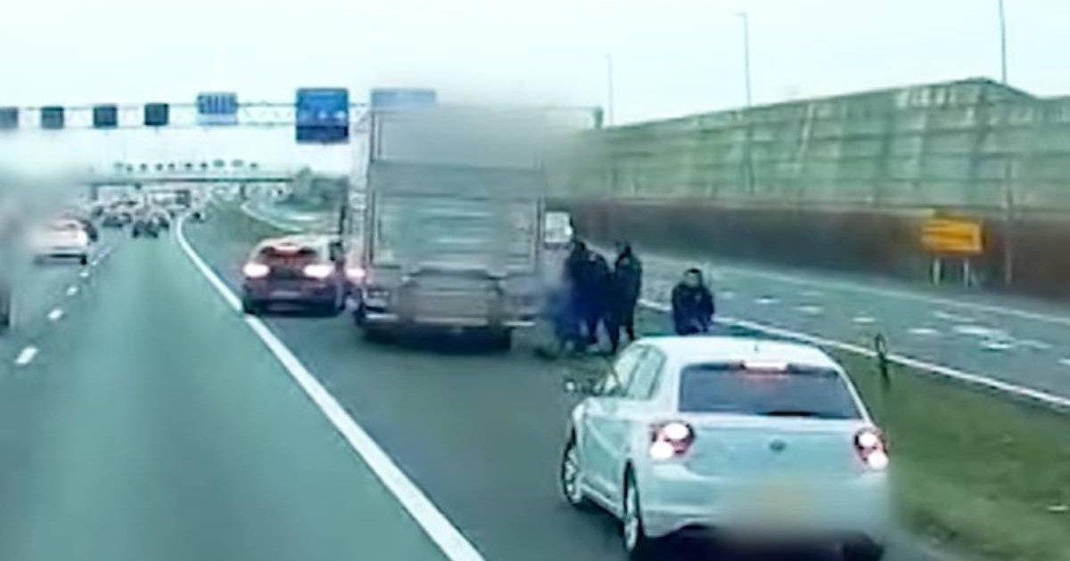 Captură video filmare șofer martor, in dreapta, oprite pe prima banda de pe o autostrada din Olanda, un camion oprit, langa el, mai multe persoane in negru agrseaza o alta persoana aflata la pamant, imaginile sunt blurate, in fata camionului se vede o altă masina de culoare inchisa, cu avariile pornite, in spate o masina alba, Olanda