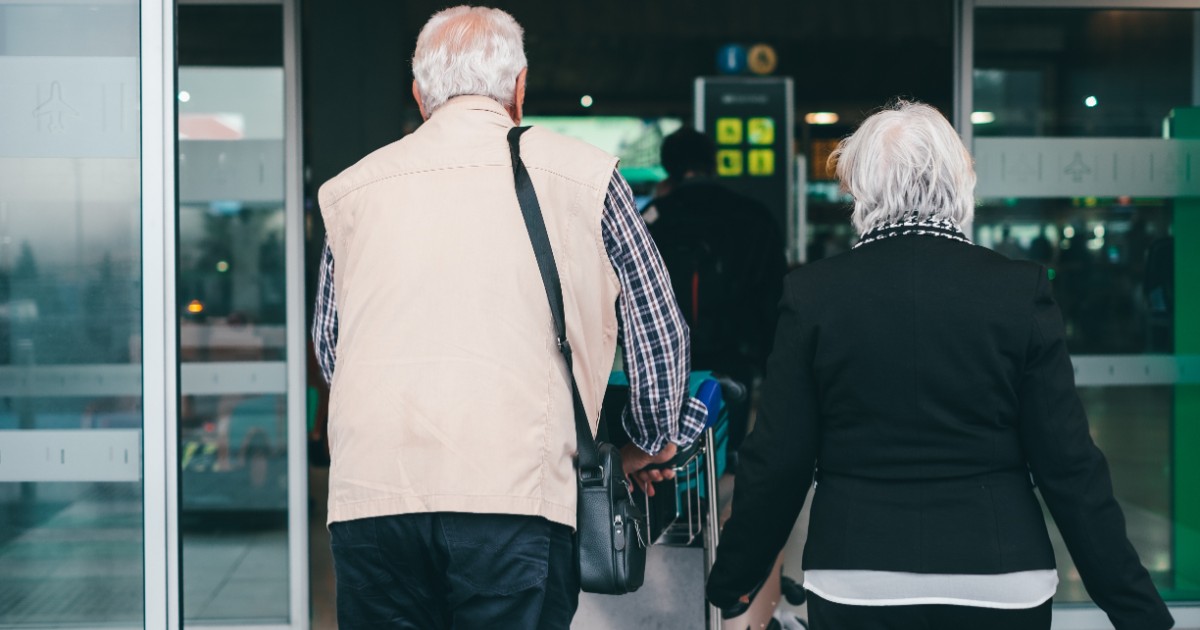 Un cuplu de pensionari care intră într-un aeroport.