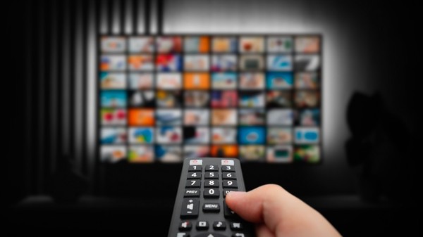 Cât costă abonamentele la Netflix, Max, Disney+, Prime Video şi SkyShowtime în 2025 - Imagine cu o telecomandă îndreptată spre un TV pe ecranul căruia este afisat continutul unei platforme de streaming.