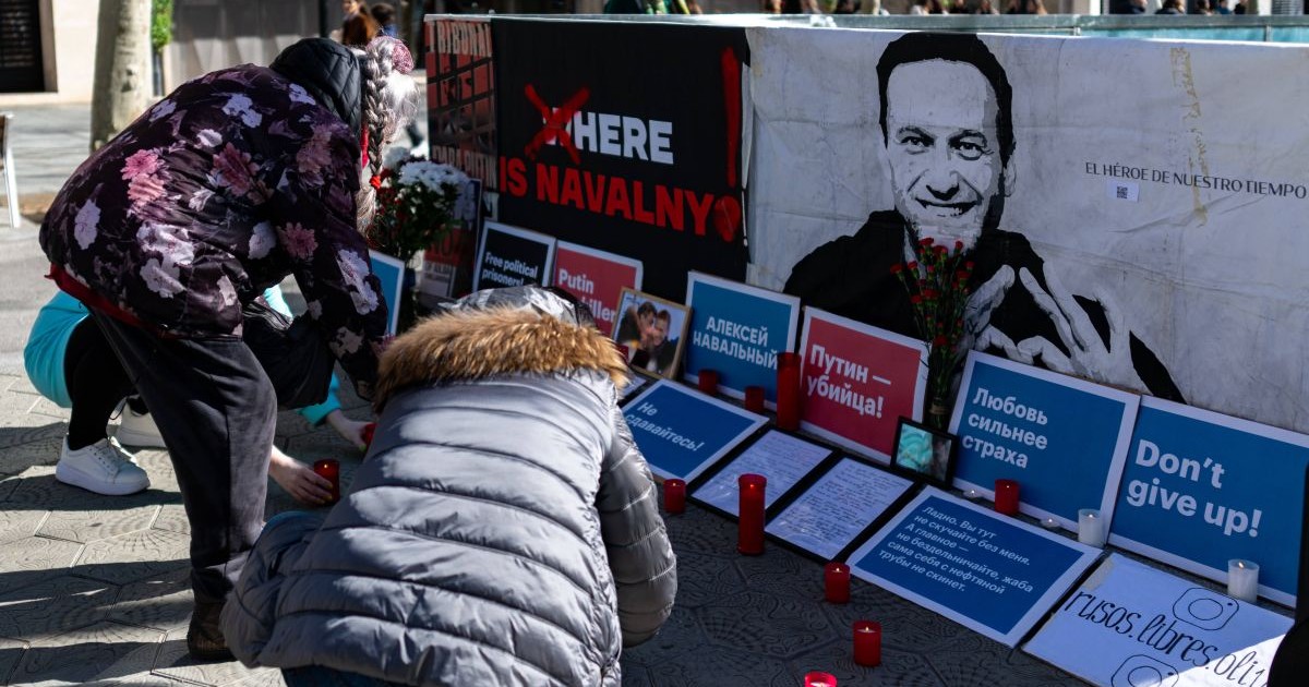 Mai multe persoane aprind candele în fața unei fotografii cu Alexei Navâlnîi din Barcelona, Spania, la doi ani de la comemorarea activistului rus mort în detenție, 15 februarie 2026