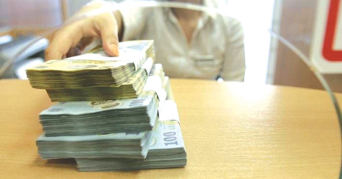 Amânarea ratelor vine la pachet cu raportarea la Biroul de Credit. Băncile spun că nu e motiv de îngrijorare. Teancuri de bani la un ghișeu bancar