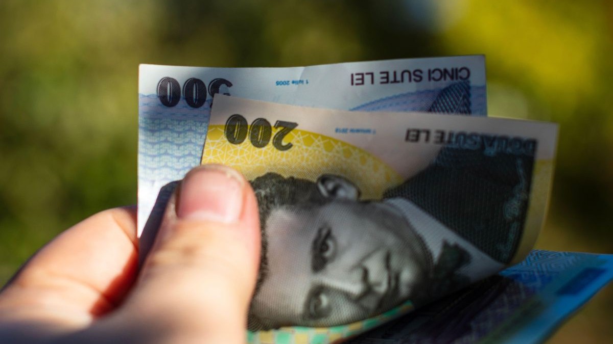 Imagine creativă cu un bărbat care ține în mână mai multe bancnote românești