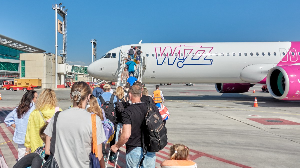 Mai mulți turiști care se urcă într-un avion Wizz Air de pe un aeroport