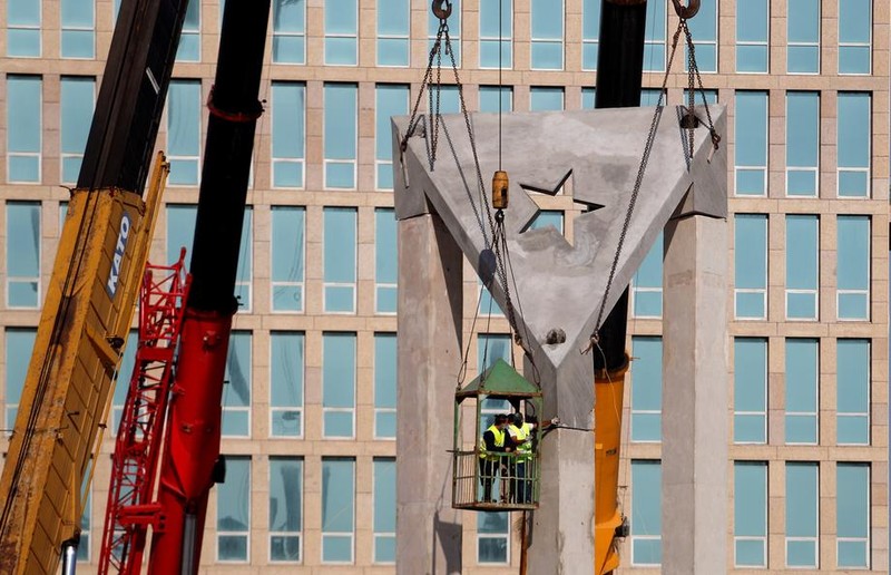epa09111305 Workers raise a giant concrete Cuban flag on the anti-imperialist platform during its restoration, in front of the United States embassy, in Havana, Cuba, on 28 March 2021 (issued 01 April 2021). A concrete monument several meters high in the shape of the Cuban flag has been erected since this week in front of the United States Embassy in Havana, which has generated criticism for its structural deficiencies and the expenditure of resources at a critical moment. for the country's economy. EPA-EFE/Yander Zamora