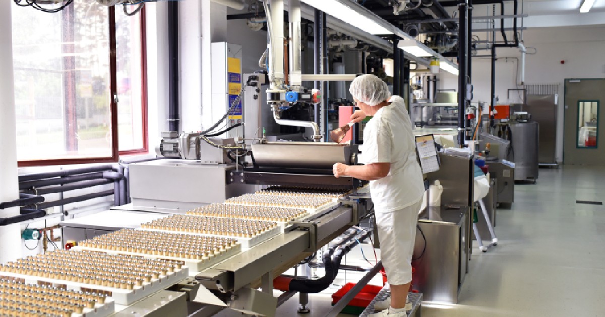 Producția de praline într-o fabrică pentru industria alimentară: o femeie verifică ciocolata