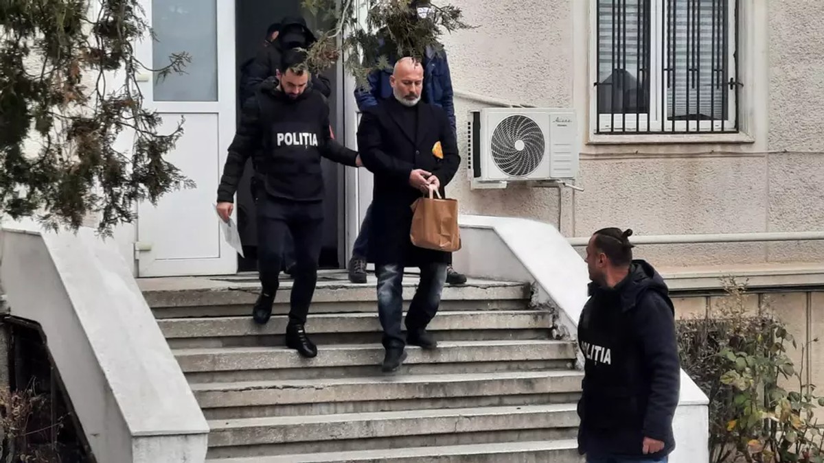 Cornel Dinicu, în cătușe, la ieșirea din sediul Poliției
