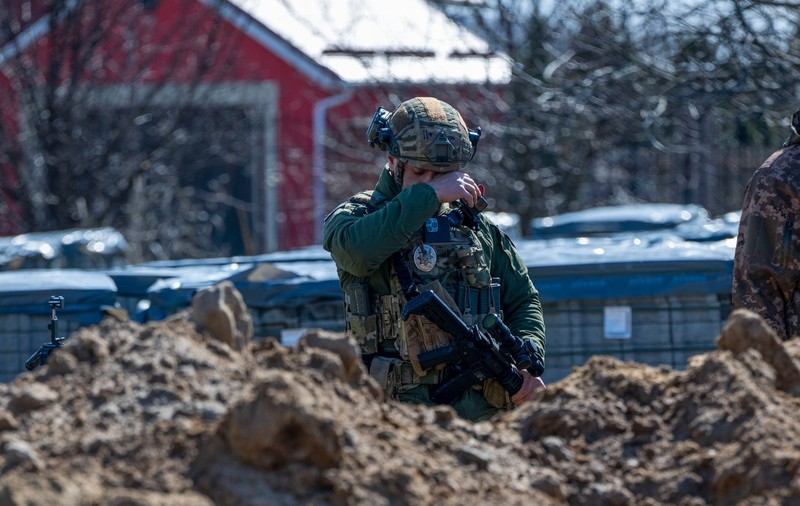 Soldat ucrainean, fotografiat plângând în fața unei gropi comune din Bucha