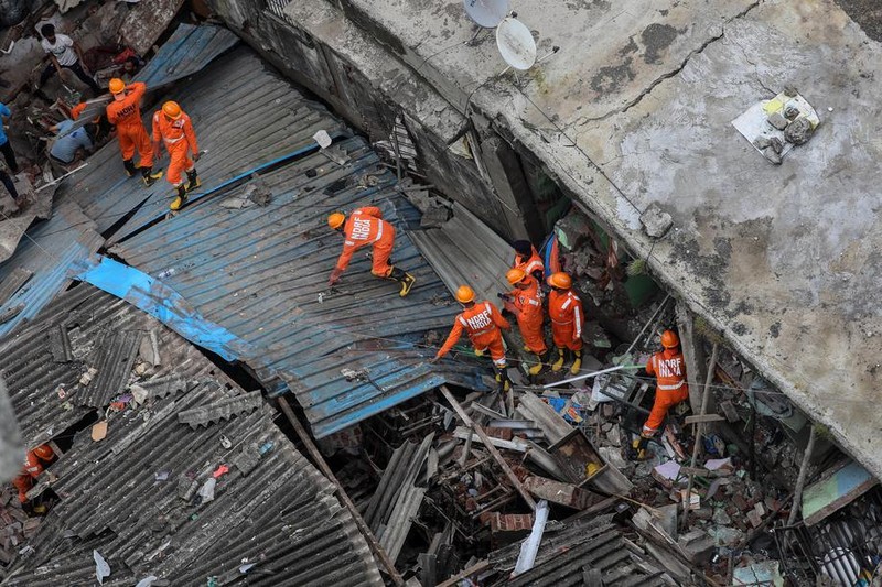 Personalul Forței Naționale de Răspuns la Dezastre (NDRF) caută supraviețuitori sub dărâmăturile clădirii prăbușite FOTO: EPA-EFE/DIVYAKANT SOLANKI