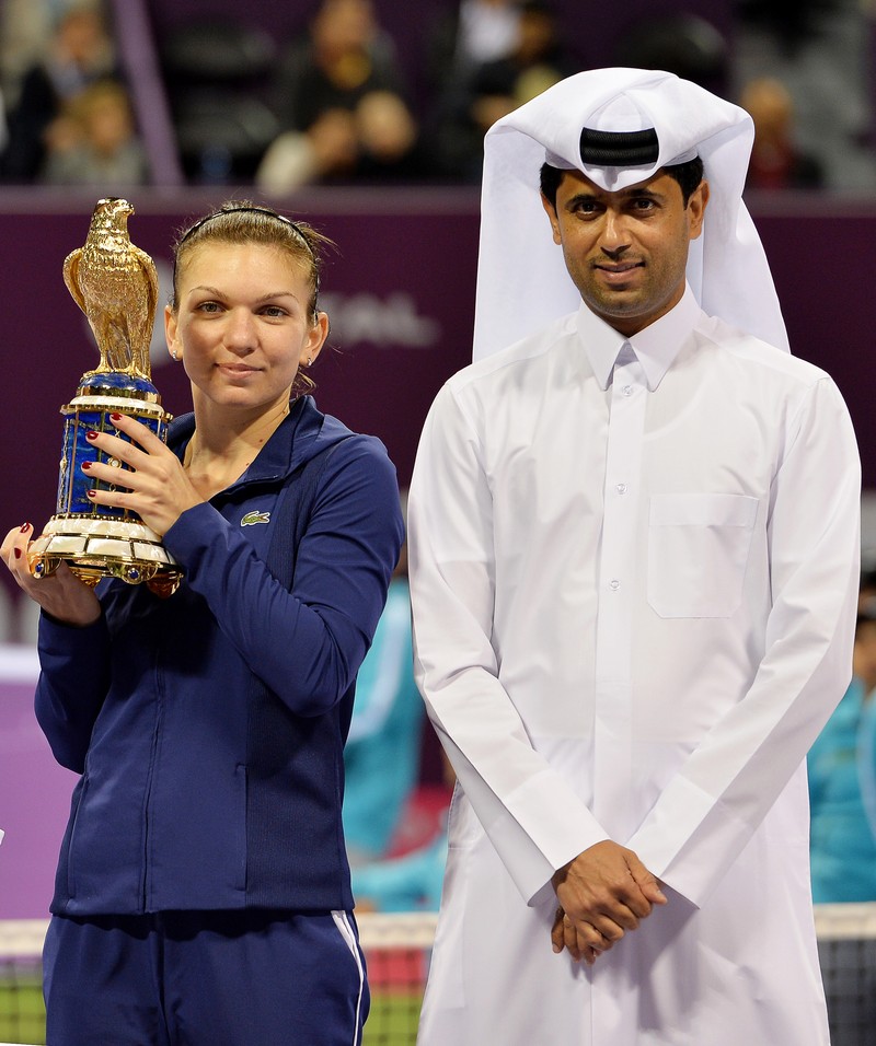 epa04081923 Simona Halep (L) of Romania poses with her trophy next to Nasser Al-Khelaifi (R), President of the Qatar Tennis Federation, after beating Angelique Kerber of Germany in the final match of the WTA Qatar Ladies Open tennis tournament at the International Khalifa Tennis Complex in Doha, Qatar, 16 February 2014. EPA/STRINGER