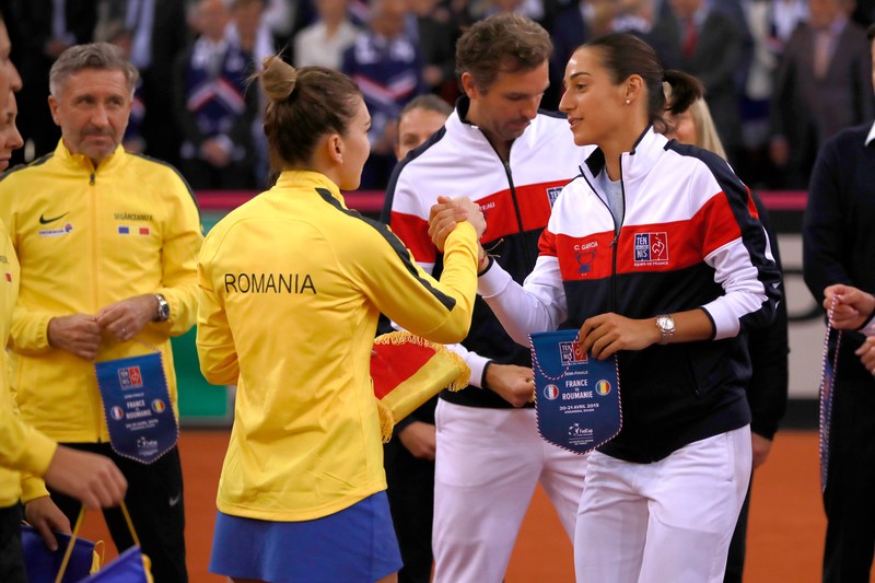 epa07517322 Caroline Garcia of France shakes hands with Simona Halep of Romania during the anthem ceremony prior to the Fed Cup World Group, Semi Final between France and Romania, in Rouen, France, 20 April 2019. EPA-EFE/CHRISTOPHE PETIT TESSON